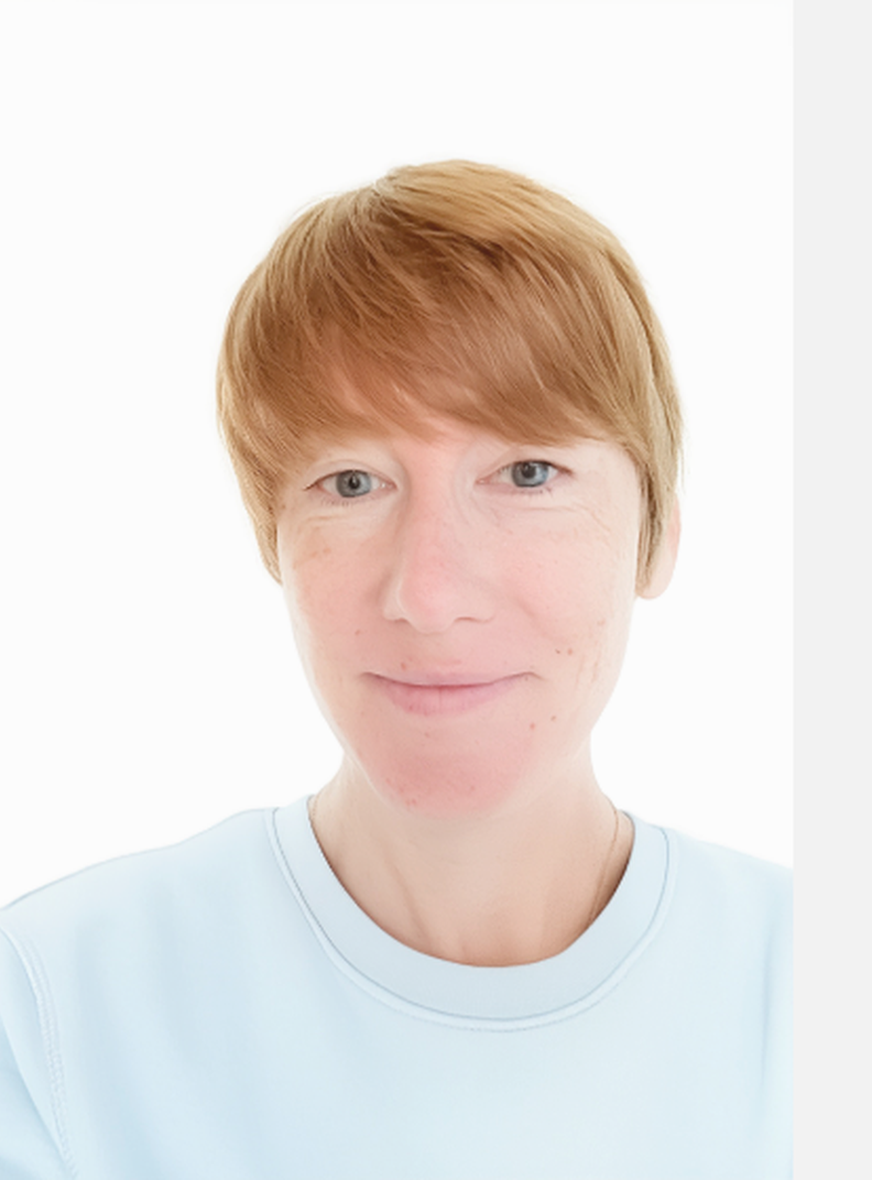 Hayley Wicker-Bradbury, Individual Giving and Legacy Manager at British Wireless for the Blind Fund. She is standing in front of a white wall, smiling, and wearing a light blue top,