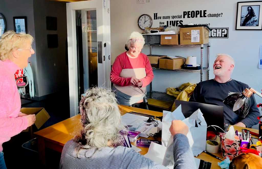 A group of volunteers laugh with Steven, our Service Delivery Manager, in our Oban hub.