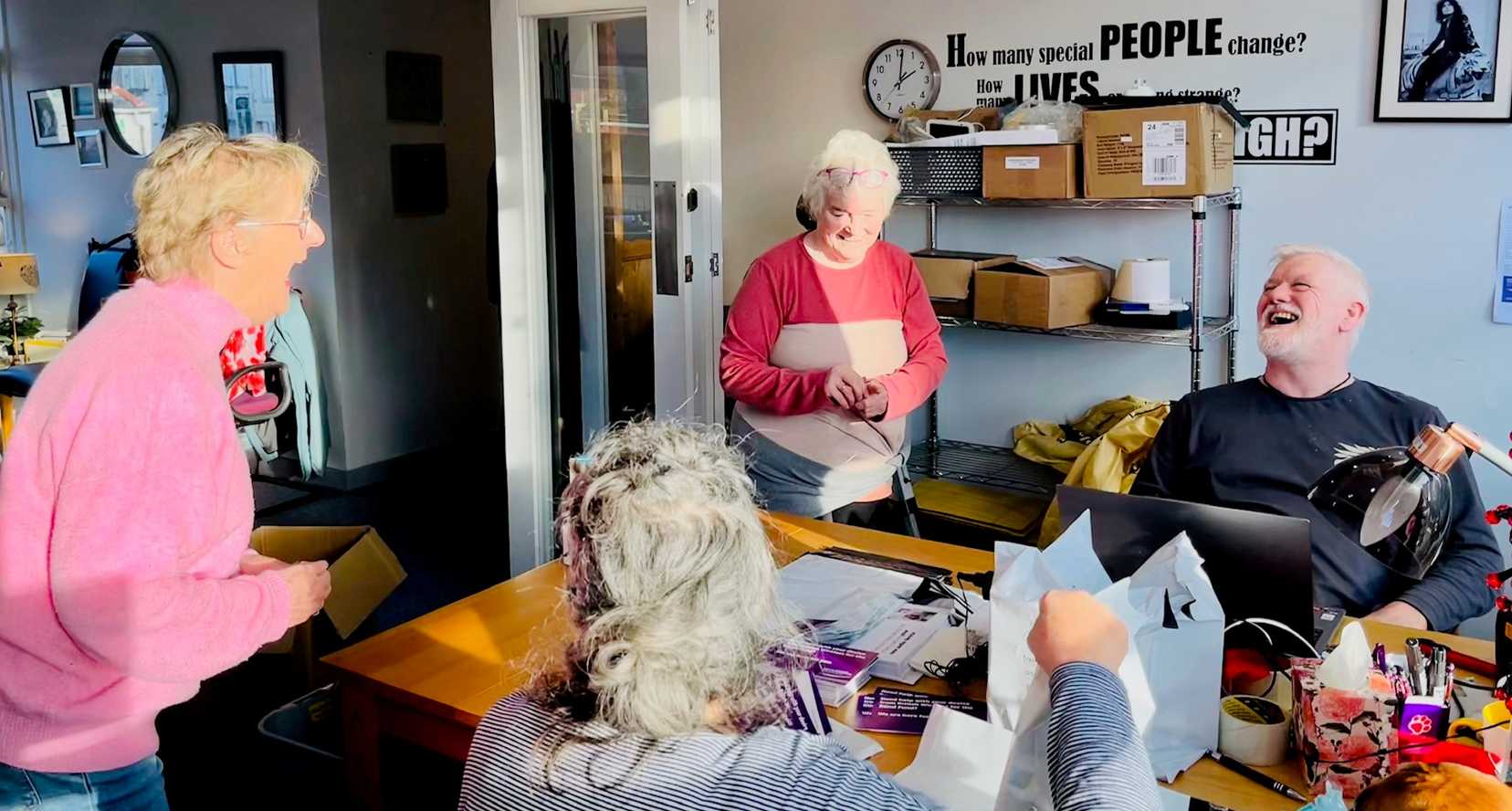 A group of volunteers laugh with Steven, our Service Delivery Manager, in our Oban hub.