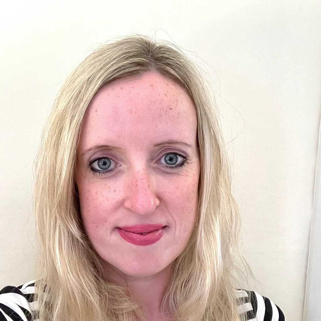 Laura-Jane Sheridan, Trusts Fundraiser, Interim, at BWBF. She is standing in front of a white wall, smiling, and is wearing a black and white striped top.