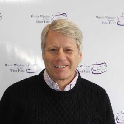 BWBF Patron Nick Ross smiles to camera. He is wearing a black jumper with a pale shirt underneath