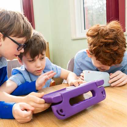 Three boys in school uniforms huddle round an iPad in a purple case