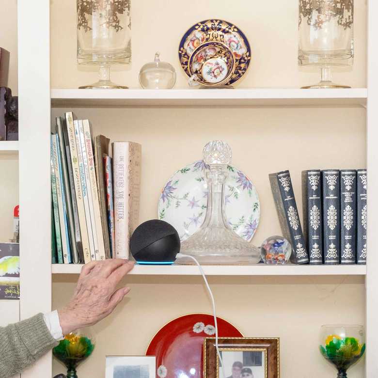 Doreen, who got a free Echo Dot from BWBF at the age of 95, smiles as she gestures to the device on her shelf.