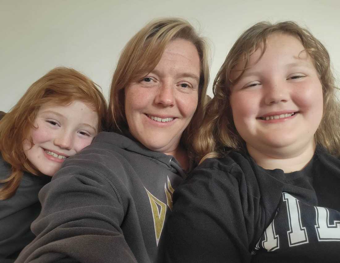 Charlie and Mathilda smile to camera with their mum, Joanna.