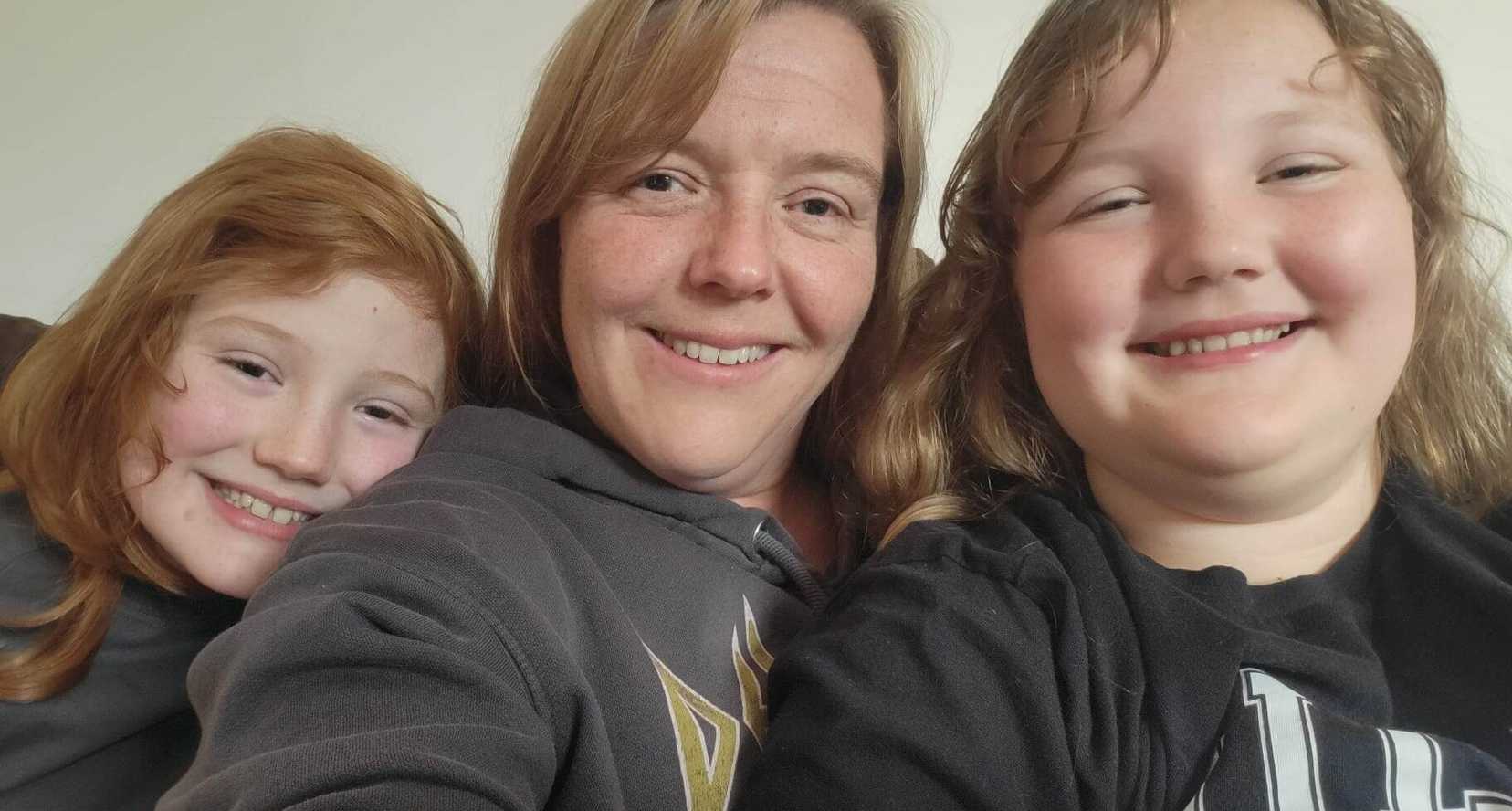 Charlie and Mathilda smile to camera with their mum, Joanna.