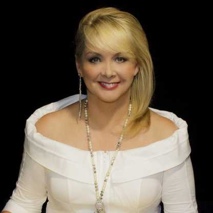 BWBF Patron Cheryl Baker smiles to camera. She is wearing a white top and her blonde hair is swept to one side.