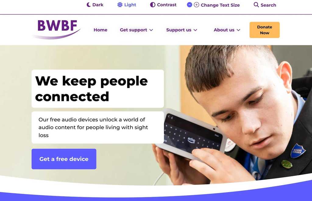 A picture of the home page of BWBF's website, with accessibility controls, site menu and a picture of a young man holding an Alexa Echo Show device